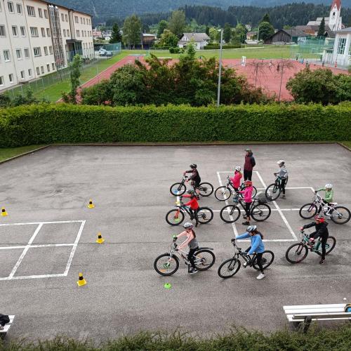 Schüler:innen warten auf die Abfahrt auf ihren Fahrrädern im Schulhof.