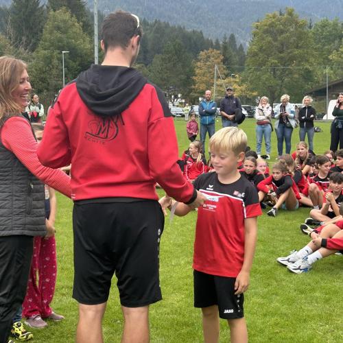 Direktorin und Lehrer gratulieren Schüler bei der Preisverteilung