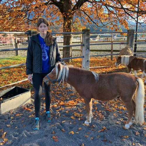 Eine Schülerin streichelt ein Pony.