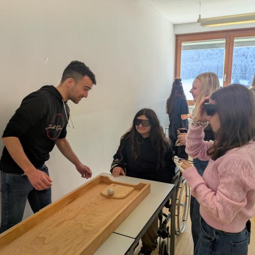 Schüler:innen tragen eine Brille, mit der man schlechter sieht und versuchen ein Spiel zu spielen.