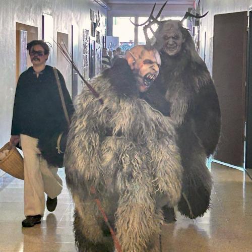 Krampusse gehen durch den Gang.
