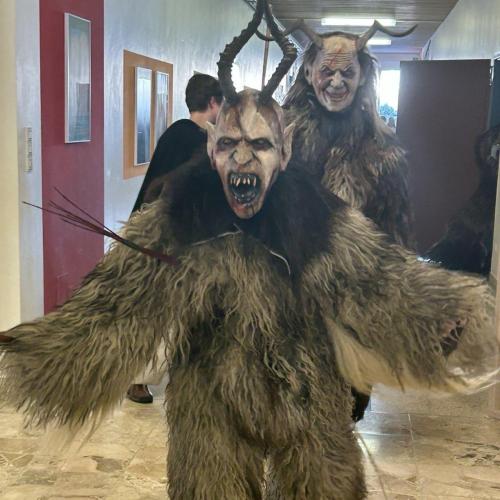 Zwei Krampus gehen auf den Fotografen zu.