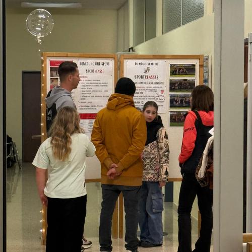 Der Sportkoordinator erklärt mit Schülern den Sportzweig.