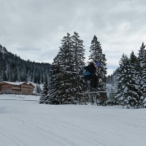 Schüler springt mit den Schi.