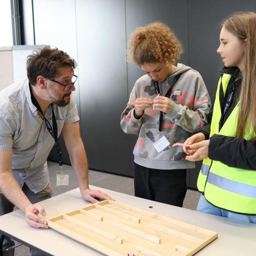 Schülerinnen unterhalten sich mit einem Mitarbeiter.