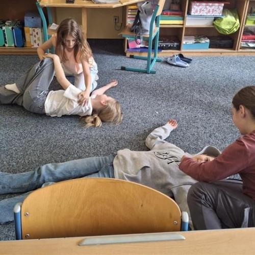 Schülerinnen bringen Mitschülerinnen in die stabile Seitenlage.