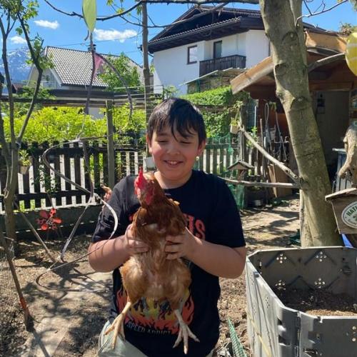 Ein Schüler hält eine Henne.