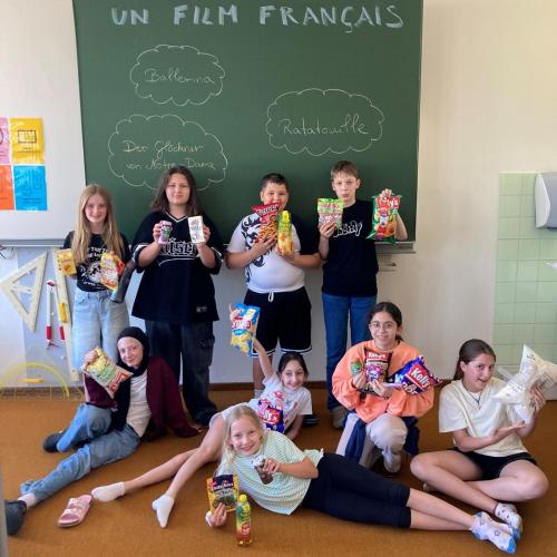 Schülerinnen vor der Tafel, auf der französische Filmtitel stehen.