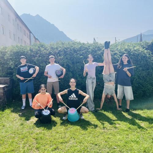 Schüler:innen präsentieren ihre Musikinstrumenten aus Eimern.