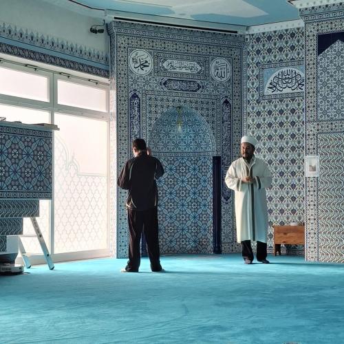 Schüler und Imam tragen etwas vor.