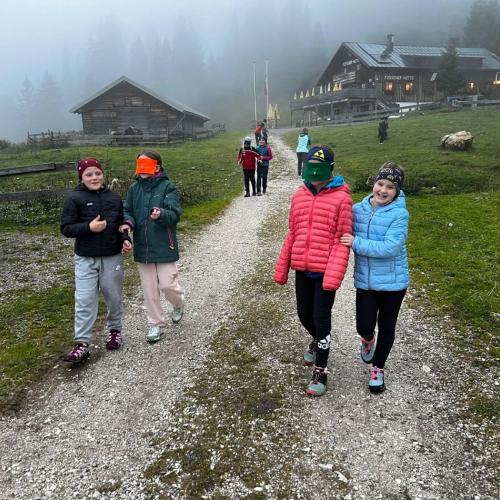 Vertrauensspiel: 1 Schülerin hat die Augen verbunden und eine andere führt sie durch das Gelände.