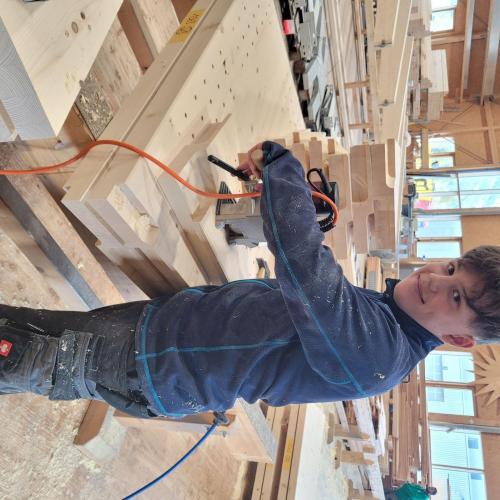 Schüler bei Holzbau Saurer bearbeitet Holz.