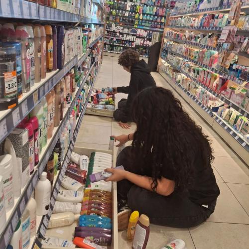 Schülerinnen beim Einräumen von Regalen.