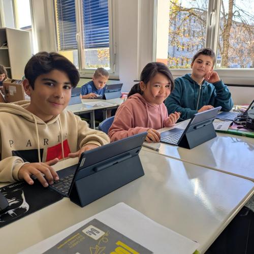 Schüler:innen der 1b Klasse arbeiten mit ihren neuen Tablets.