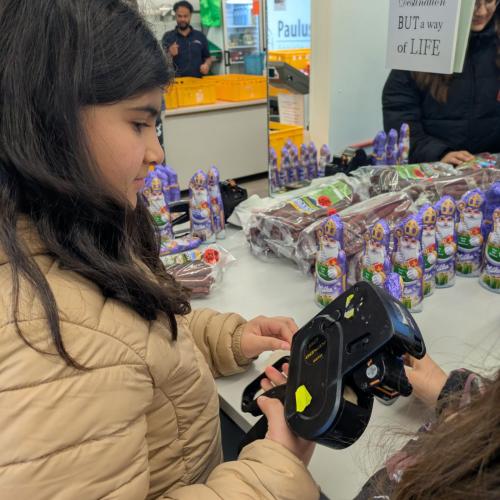 Schülerin etikettiert die Schokonikoläuse.