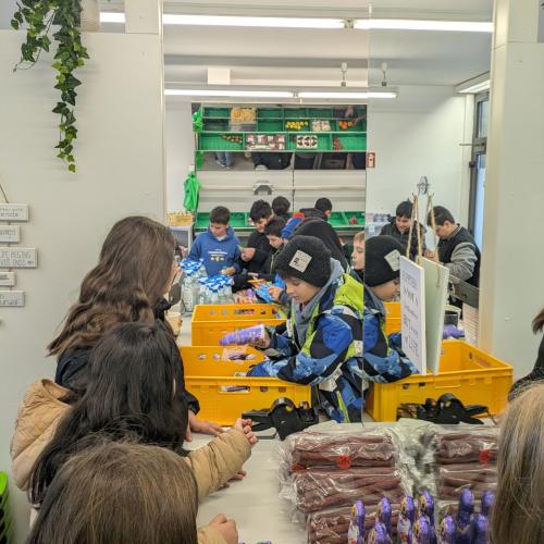 Schüler:innen sortieren und etikettieren die Waren. 