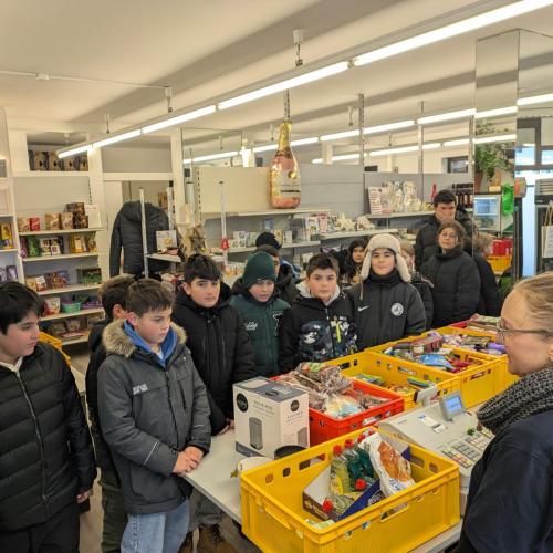 Mitarbeiterin erklärt den Schüler:innen den Ablauf im Paulusladen.