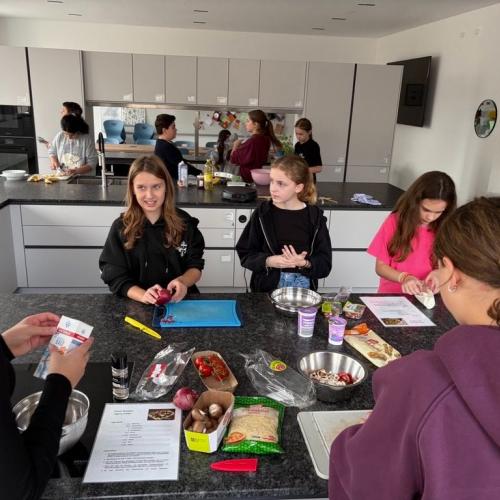 Schülerinnen bereiten eine französische Speise zu.