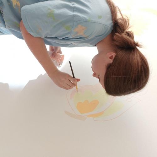 Schülerin beim Malen einer Blume.