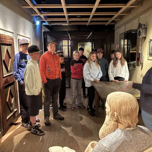 Schüler:innen hören einer Führung in einem Museum zu. 