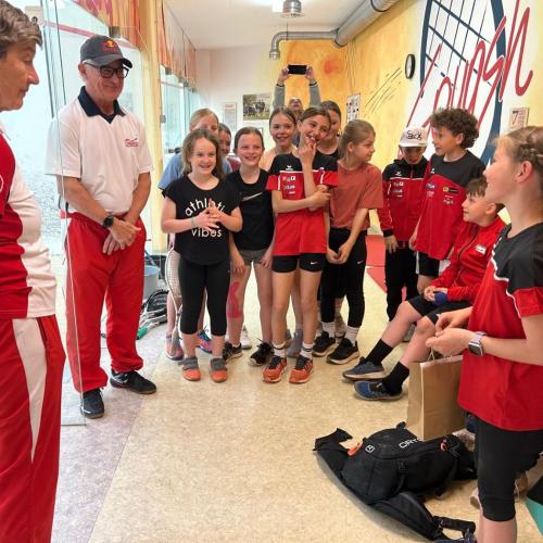 Schüler:innen lauschen den Squashtrainern.
