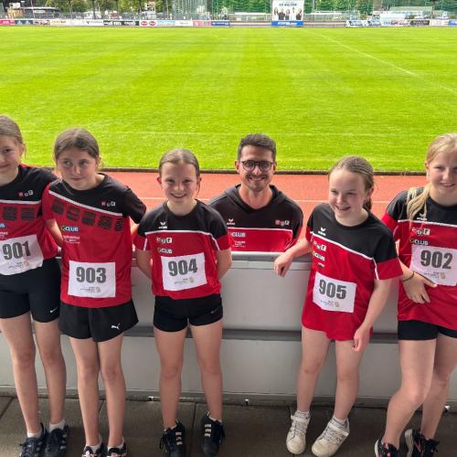 Gruppenfoto Schüler:innen im schwarz, roten Schuldress  vor der Laufstrecke.