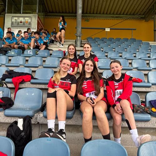 Gruppenfoto Schüler:innen im schwarz, roten Schuldress auf der Tribüne.