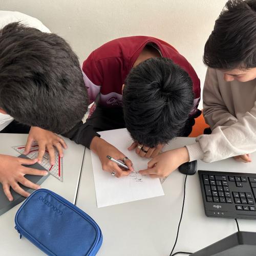Drei Schüler sitzen am Design für den 3D-Drucker.