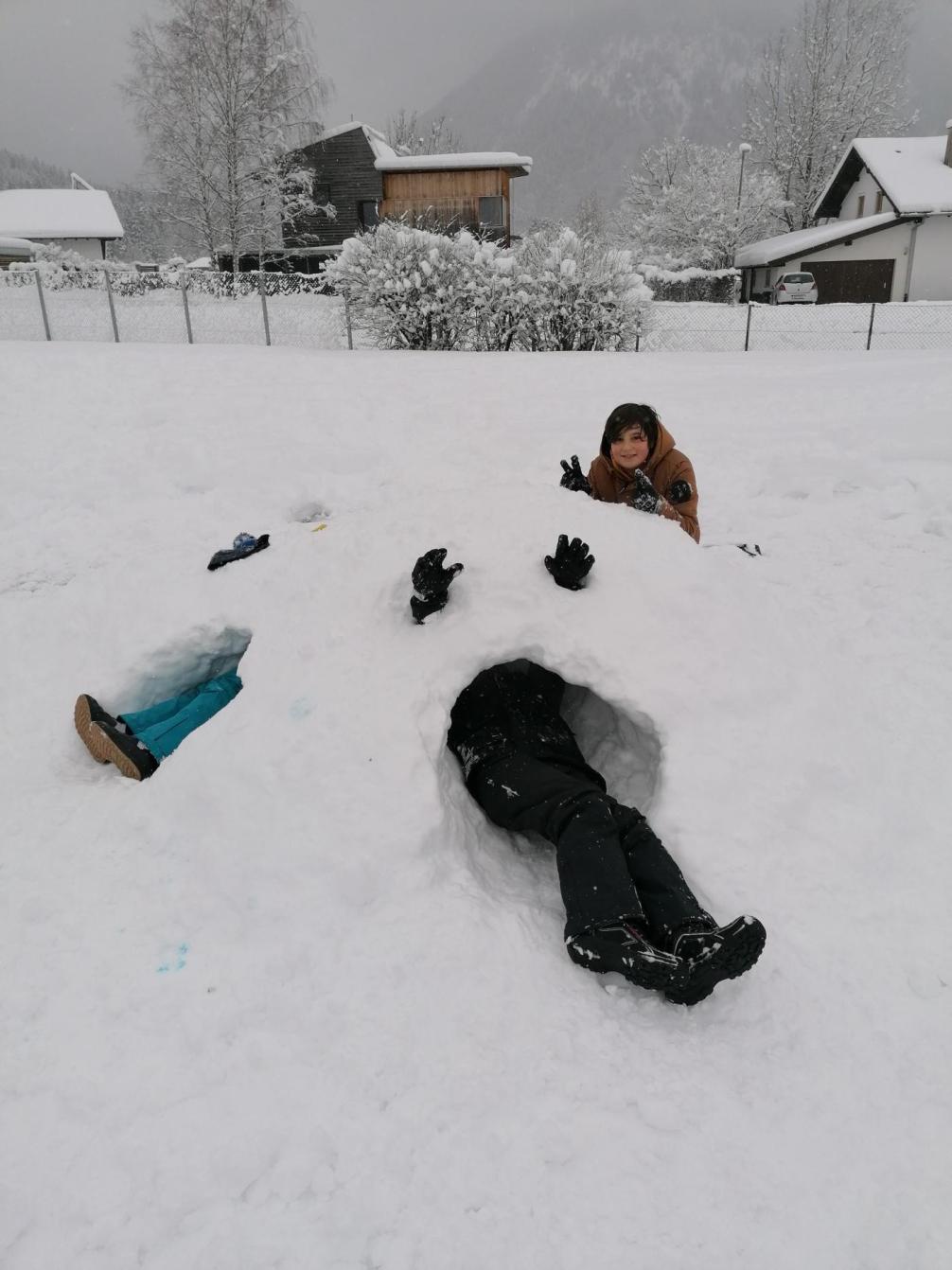 Mehrere Kinder in Schneehöhlen