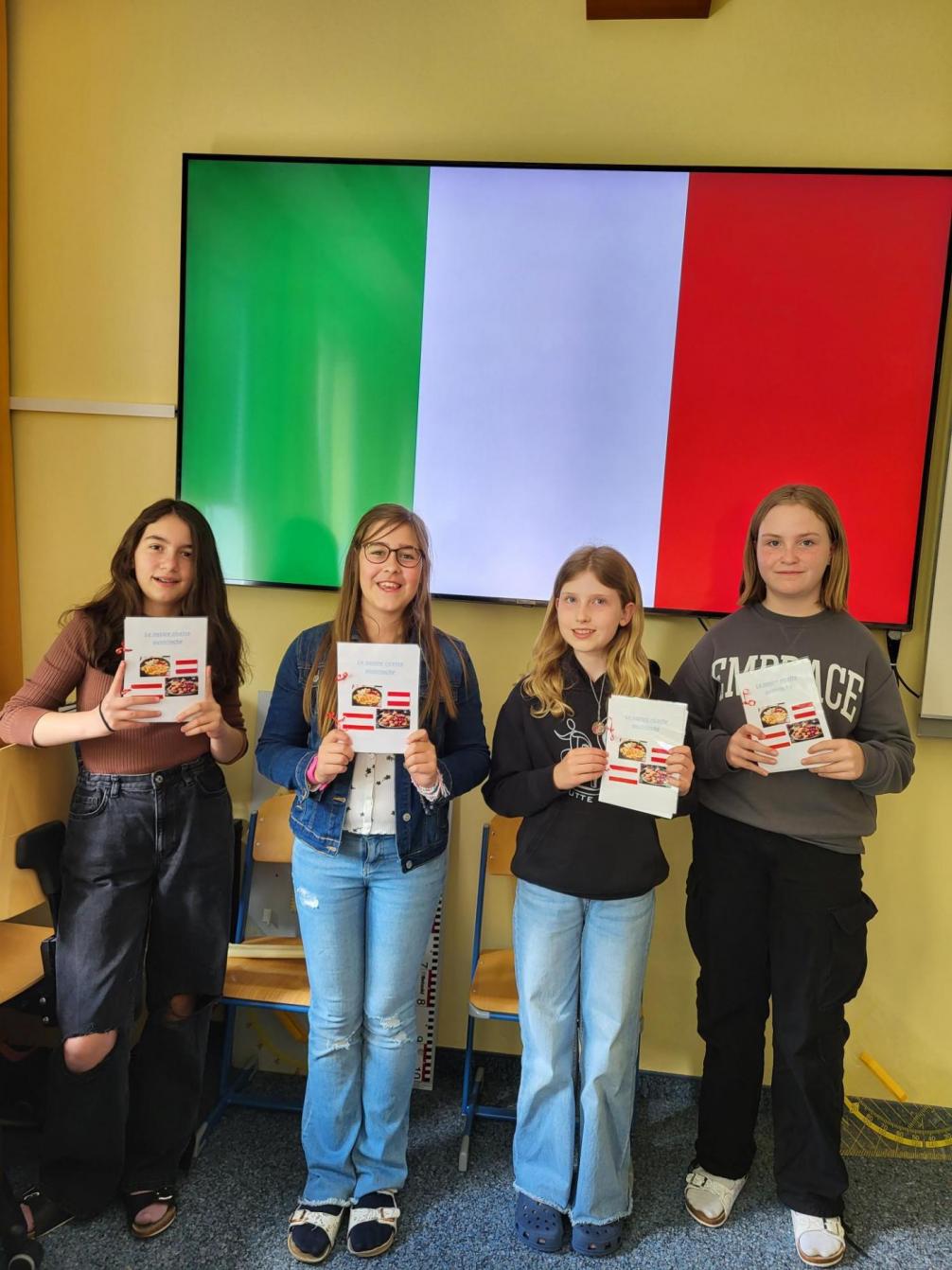 Schülerinnen zeigen ihr Rezeptheft, das sie auf Italienisch verfasst haben.