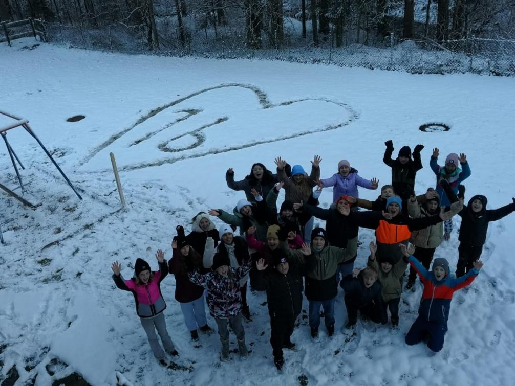 Gruppenfot 1b und im Hintergrund ein Herz im Schnee in dem 1b geschrieben steht.