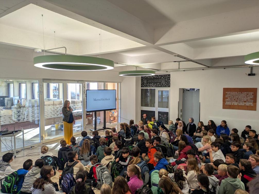 Direktorin begrüßt die Schüler:innen im neuen Schuljahr im Foyer des neuen Schuljahres.