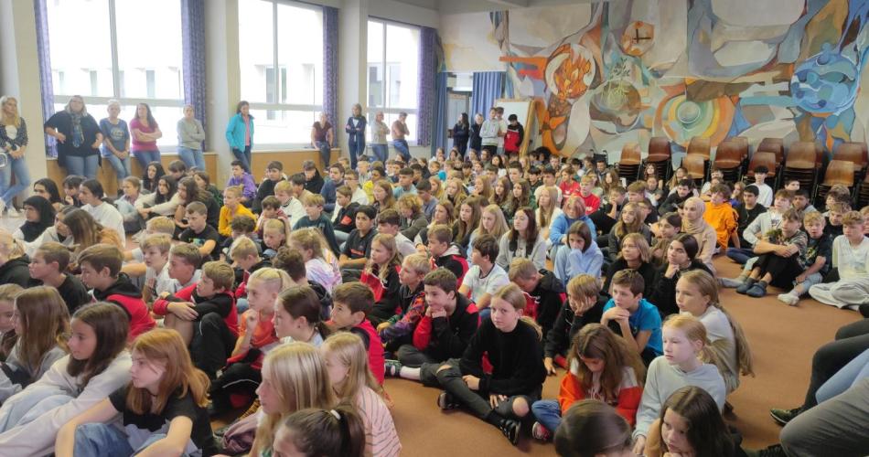 Schülerinnen und Schüler der MSK sitzen gemeinsam in der Aula