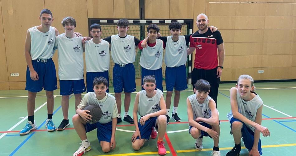 Gruppenfoto der Spieler:innen mit der Lehrperson.