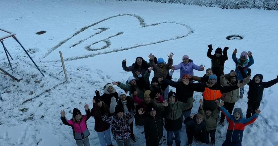 Gruppenfot 1b und im Hintergrund ein Herz im Schnee in dem 1b geschrieben steht.