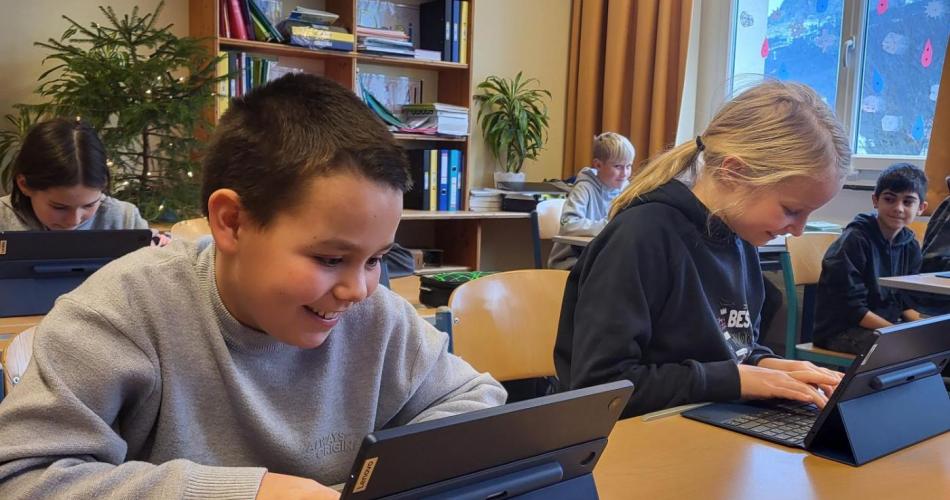 Schüler:innen arbeiten mit dem Tablet.