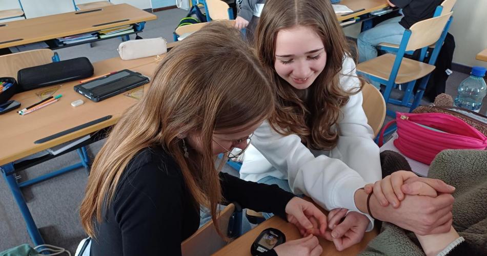 Schüler:innen messen einander den Blutzucker.