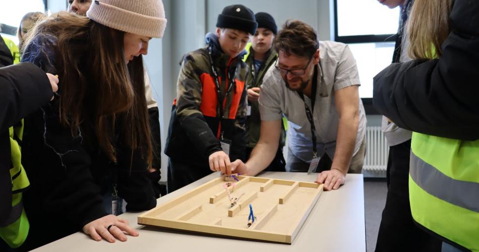 Mitarbeit zeigt den Schüler:innen ein Projekt.