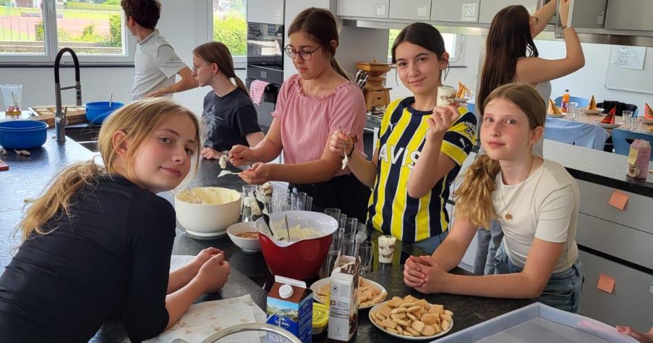 Schülerinnen bereiten ein Tiramisu vor.