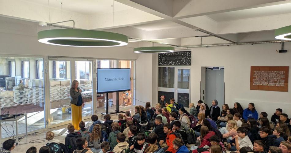 Direktorin begrüßt die Schüler:innen im neuen Schuljahr im Foyer des neuen Schuljahres.