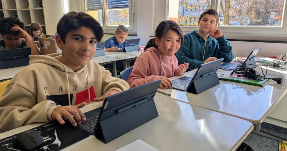 Drei Schüler:innen arbeiten mit ihren neuen Tablets. 