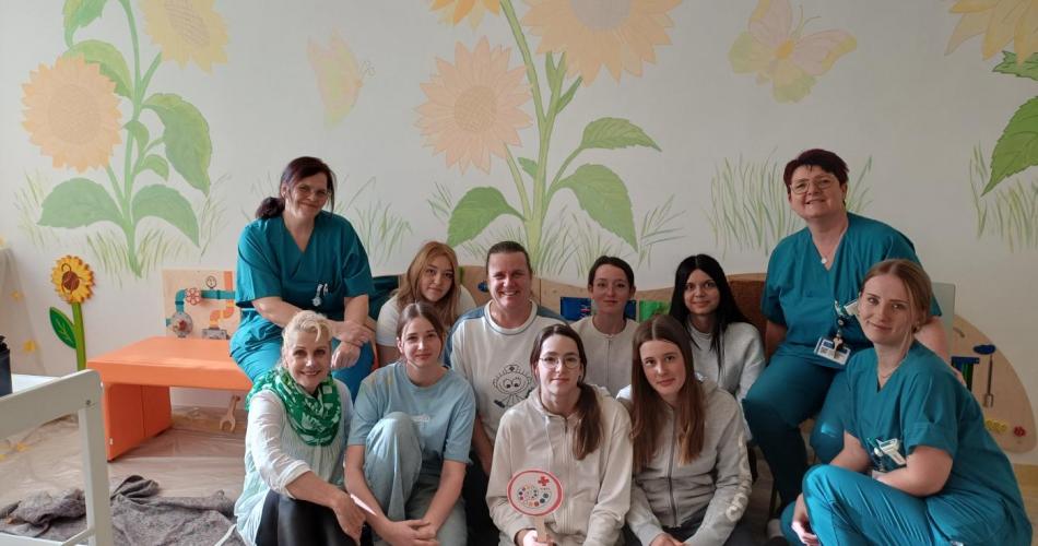 Gruppenfoto der Schüler:innen, die gemalt haben, gemeinsam mit den Krankenschwestern.