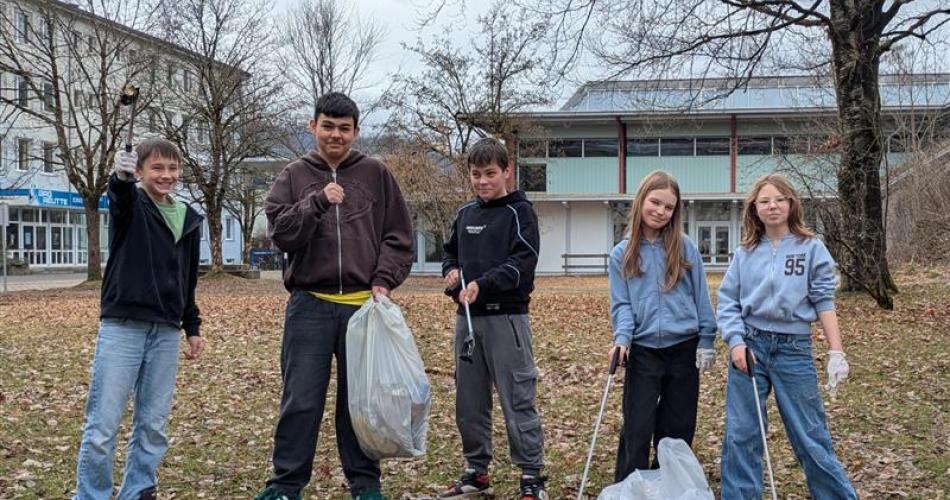 5 Schüler:innen beim Müll sammeln, um unsere Schulzentrum zu säubern.