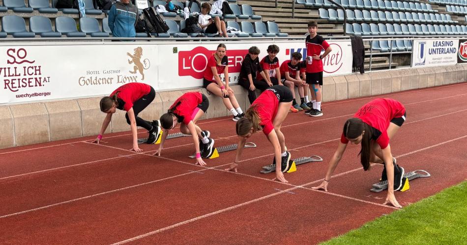 Schüler:innen im schwarz, roten Schuldress beim Start, kurz vor dem Sprint.