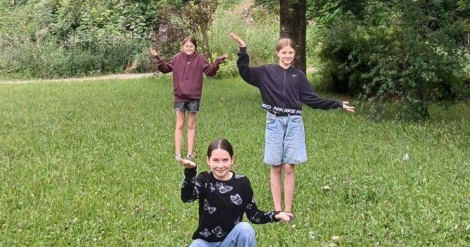 Es scheint, als wäre eine Schülerin die Waage und links und rechts auf den Händen balancieren zwei Schülerinnen.