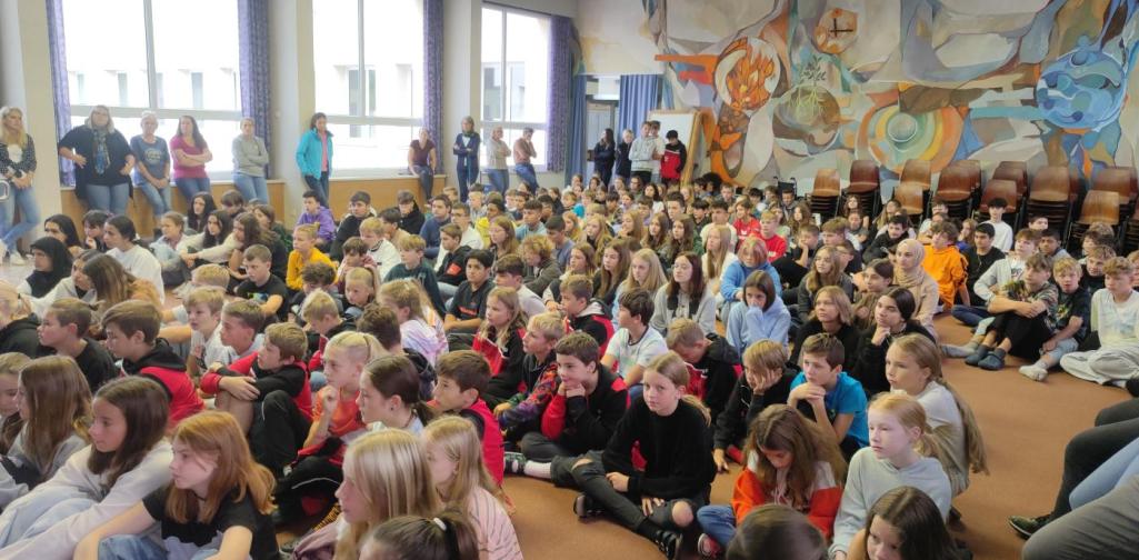 Schülerinnen und Schüler der MSK sitzen gemeinsam in der Aula