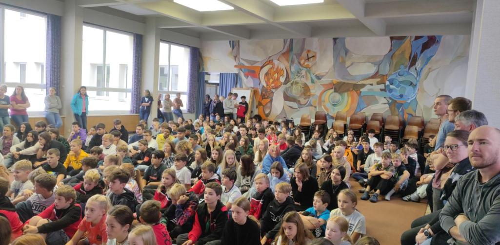 Schülerinnen und Schüler der MSK sitzen gemeinsam in der Aula